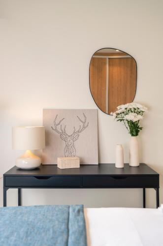 a table with a mirror and a vase with flowers at Mar-Gi 25 in Aiándion