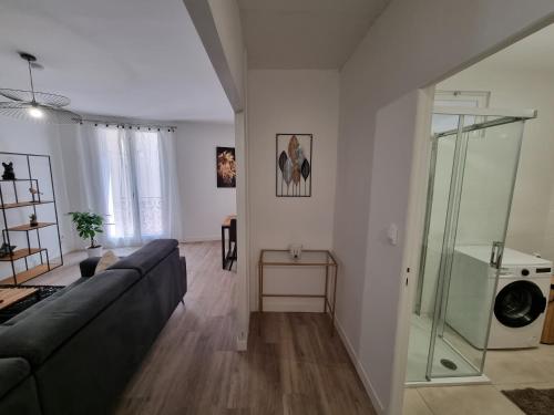 een woonkamer met een bank en een glazen douche bij etienne dollet in Béziers