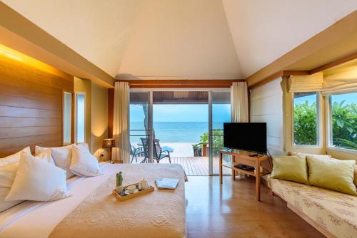 a bedroom with a large bed with a view of the ocean at Veranda Lodge in Hua Hin