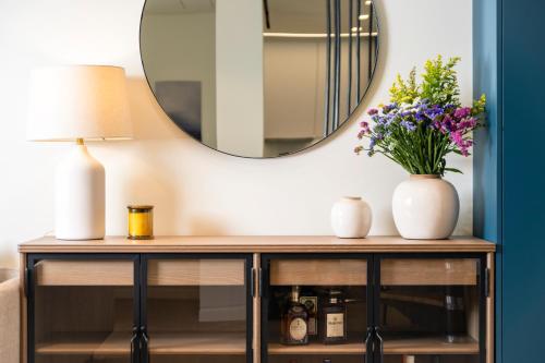 a dressing table with a mirror and flowers on it at Mar-Gi 25 in Aiándion