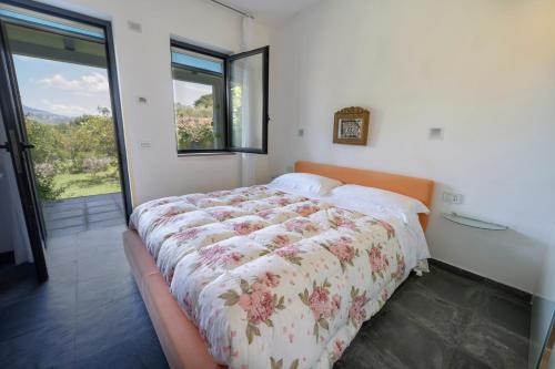 1 dormitorio con 1 cama con edredón de flores en Giacaranda B&B, en Castellabate