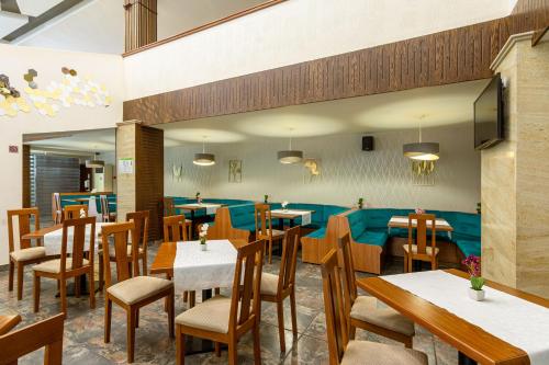 a restaurant with tables and chairs in a room at BSA Gradina Hotel & Aquapark - All Inclusive in Golden Sands