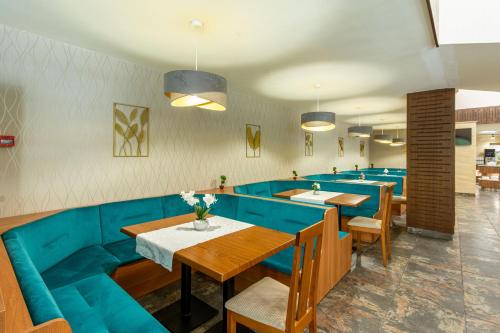 a restaurant with blue seats and tables in a room at BSA Gradina Hotel & Aquapark - All Inclusive in Golden Sands