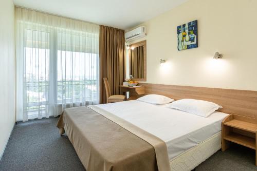 a hotel room with a large bed and a window at BSA Gradina Hotel & Aquapark - All Inclusive in Golden Sands