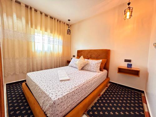 a bedroom with a bed and a window at Salam appartement in Azrou
