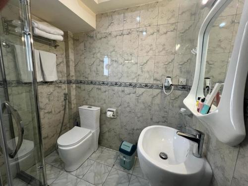 a bathroom with a toilet and a sink and a shower at فندق البيت الصغير - Lapetite Maison Hotel in Baghdād