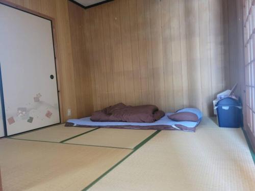 a bed in a corner of a room at 하루카오후나에 민숙 in Tsushima