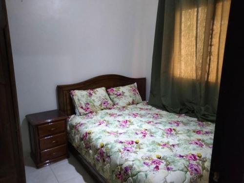 um quarto com uma cama com flores em Apartment in the center of marrakech for a good price em Marrakech