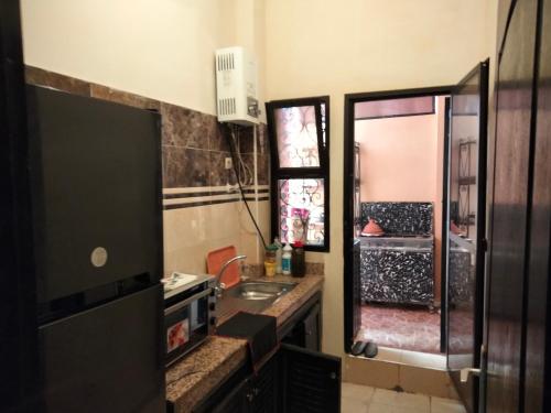uma casa de banho com um lavatório, uma janela e uma televisão em Apartment in the center of marrakech for a good price em Marrakech