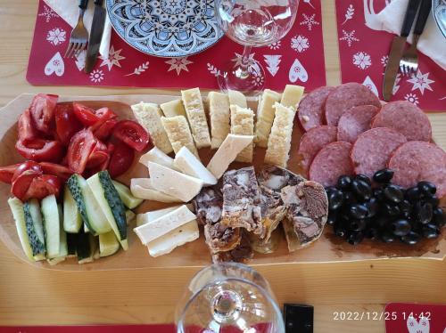 una tabla de cortar con diferentes tipos de queso y aperitivos en Cabana familiei, 