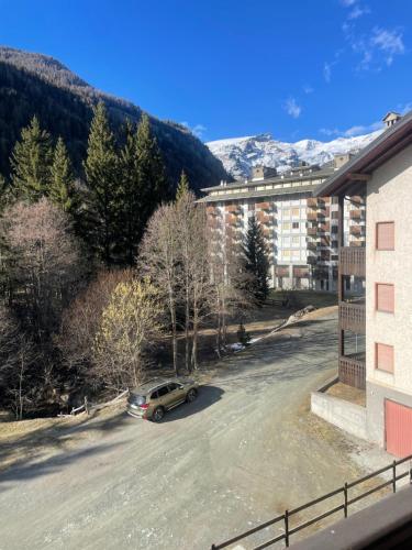 ein Auto, das auf einem Parkplatz neben einem Gebäude parkt in der Unterkunft Raffinatezza a 50 m dalle piste in Champoluc