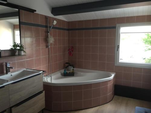 une salle de bain avec une baignoire et un lavabo dans l'établissement A La Rochelle proche Vélodyssée et parking privé, à La Rochelle