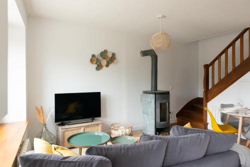 a living room with a couch and a fireplace at Au rêve salé in Hillion