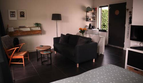 a living room with a couch and a table at B & B De Rode Beuk in Hilvarenbeek