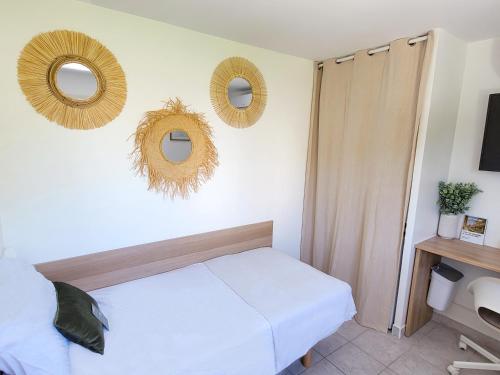 a bedroom with a bed and two mirrors on the wall at Chambre simple climatisée - Proche Tram & Centre in Montpellier