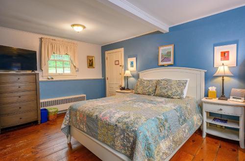 a bedroom with blue walls and a bed and a window at Brass Lantern Inn in Stowe