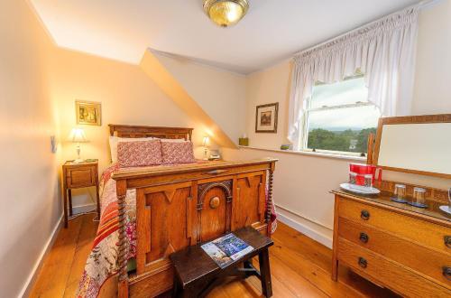 a bedroom with a bed and a dresser and a window at Brass Lantern Inn in Stowe