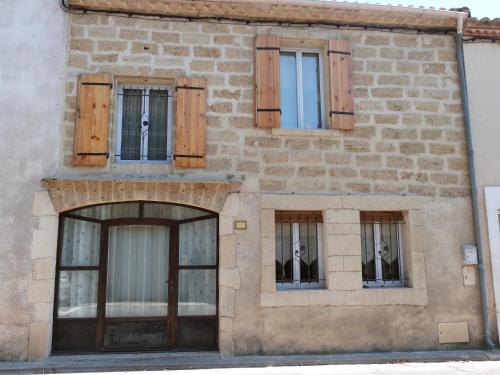 un bâtiment en briques avec quatre fenêtres et portes dans l'établissement La Remise, à Le Cailar