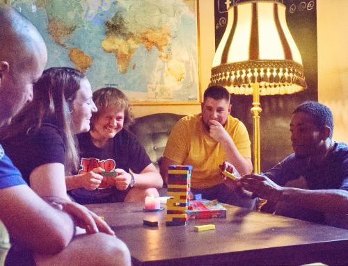 a group of people sitting around a table playing a game at Cinnamon Sally Backpackers Hostel in Rīga