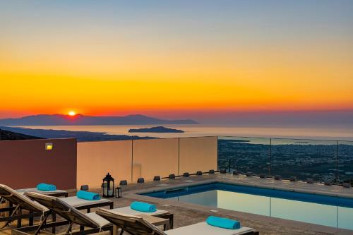 a pool on the roof of a building with a sunset at Villa Nektar with private ecologic pool and amazing view! in Kondópoula