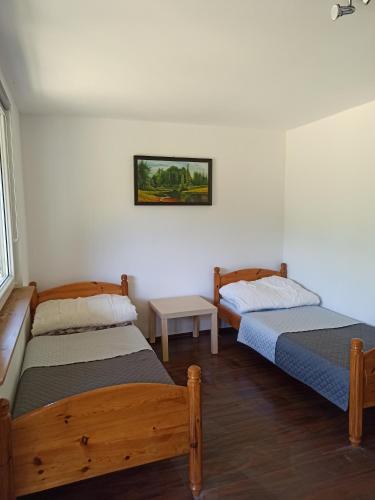 a bedroom with two beds and a table in it at Zakątek Turysty in Świbno