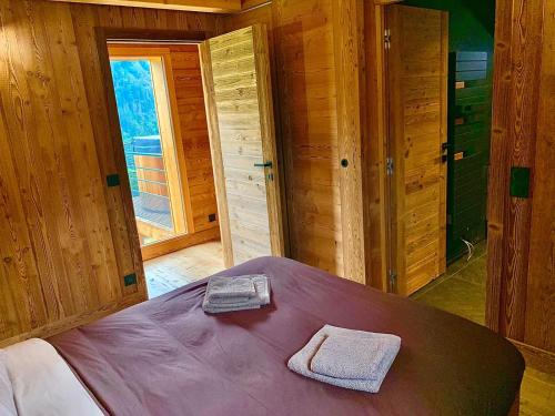 1 dormitorio con 1 cama con 2 toallas en chalet du Champel jacuzzi, en Saint-Gervais-les-Bains