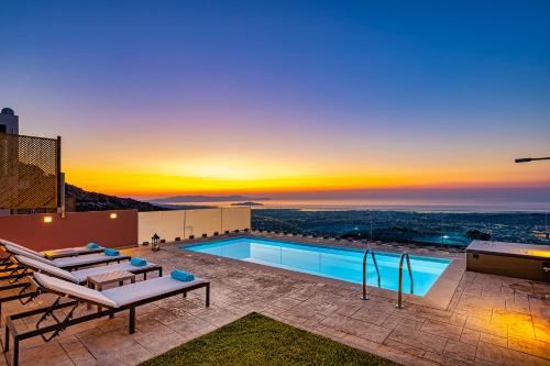 a pool on the roof of a building with a sunset at Villa Nektar with private ecologic pool and amazing view! in Kondópoula