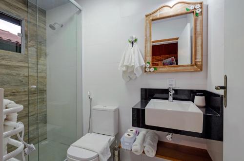 a bathroom with a sink and a shower at Chalé Flores e Amores in Visconde De Maua