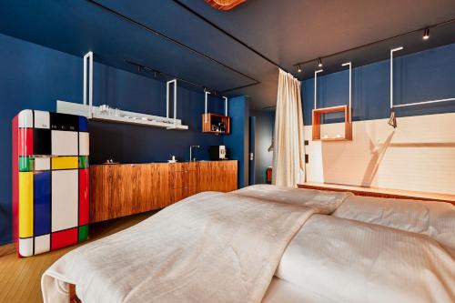 a bedroom with a large bed and blue walls at Bettstadt Apartments in Vipiteno