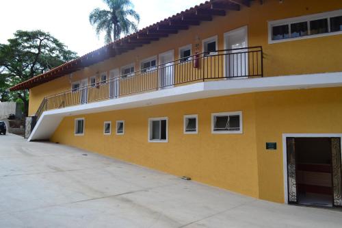 a yellow building with a balcony on the side at Hotel Portal do Éden in Sorocaba