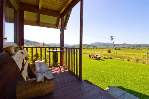 a porch of a house with a view of a field at Polna Przystań in Uherce Mineralne