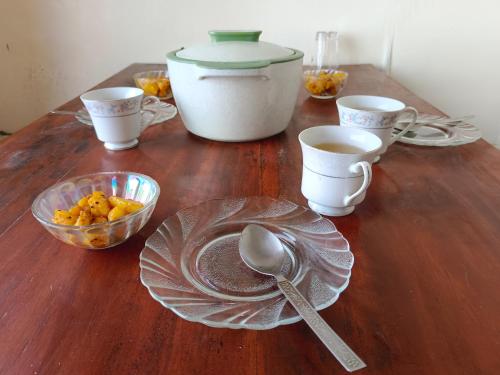 a wooden table with a bowl of food and a spoon at International Youth Hostel and Homestay Kurseong Bazar in Kurseong