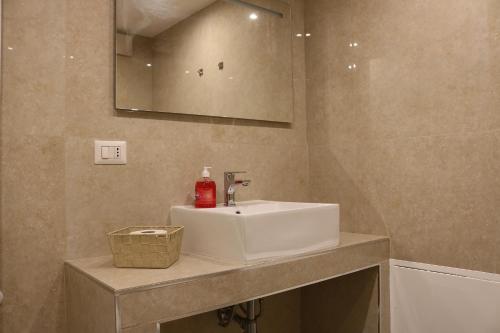 een badkamer met een witte wastafel en een spiegel bij Michelangelo Navigli Loft Experience - Via Magolfa in Milaan