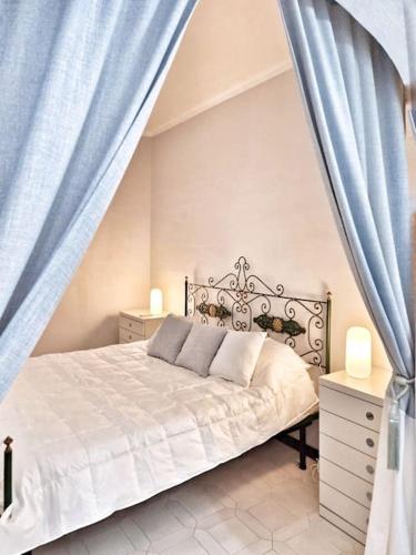a bedroom with a bed with blue curtains at ViSte in Porto Santo Stefano