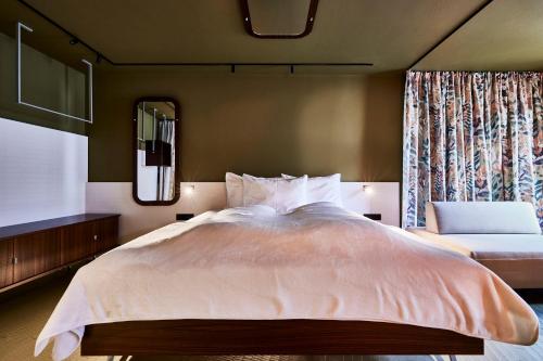 a bedroom with a large bed and a mirror at Bettstadt Apartments in Vipiteno