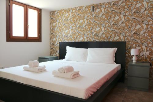 1 dormitorio con 1 cama con 2 toallas en Michelangelo Navigli Loft Experience - Via Magolfa en Milán