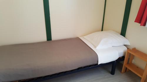 a small bed in a room with a wooden table at La Grange du Héron in Balaguier-dʼOlt