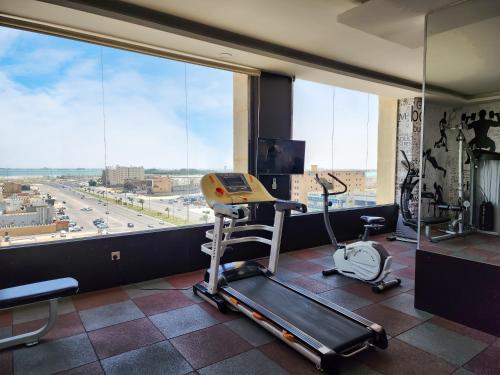 a room with a gym with a treadmill and a large window at Holiday Al Khaleej Hotel in Al Khobar