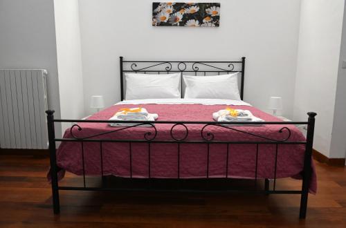 a bed with a red blanket and two towels on it at Loft Mazzini in Caserta
