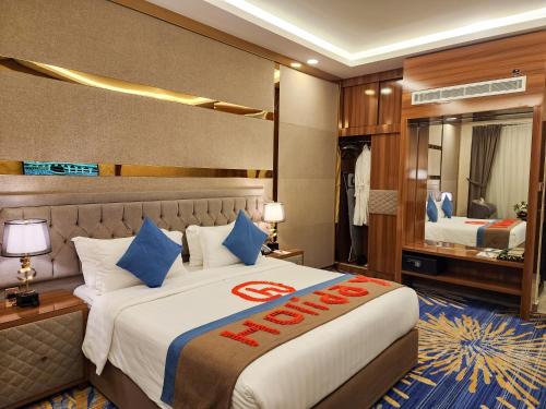 Habitación de hotel con cama grande con almohadas azules en هوليداي الخليج الخبر Holiday Al Khaleej Hotel, en Al Khobar