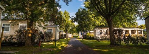 une route entre deux maisons avec des arbres dans une cour dans l'établissement La Réserve 4 étoiles emplacement 844 3CH 2SDB 6 personnes, à Gastes