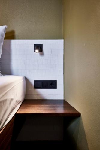 a room with a bed and a light on a wall at Bettstadt Apartments in Vipiteno