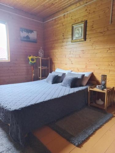 a bedroom with a bed and a wooden wall at Wooden house in Hondol
