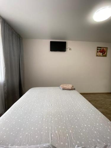a bedroom with a white bed with a tv on the wall at Двокімнатні апартаменти в ЖК Щасливий Запорізьке шосе 30 in Dnipro