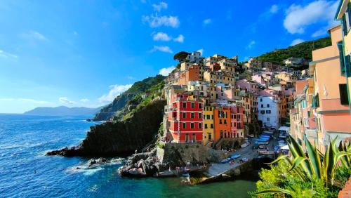 a group of buildings on a hill next to the ocean at La Casa delle Pietre Parlanti - Casa in pietra ai piedi del parco delle 5 Terre in Biassa