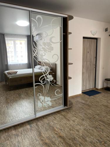 a room with a glass wall with a bed in it at Двокімнатні апартаменти в ЖК Щасливий Запорізьке шосе 30 in Dnipro