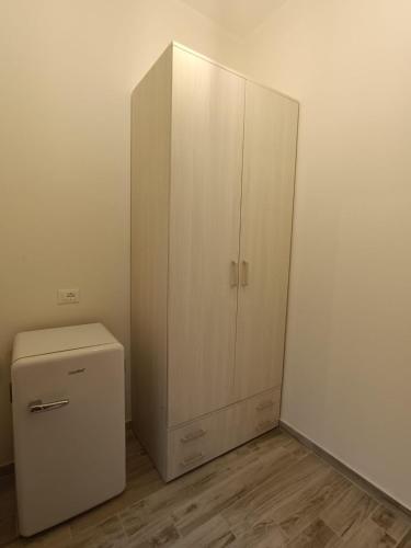 a white cabinet next to a refrigerator in a room at La Casa Di Lucia in San Vito Chietino