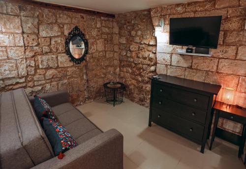 sala de estar con sofá y TV de pantalla plana en Tony Guesthouse, en Acre