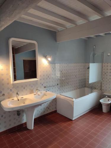 une salle de bain avec une baignoire et un lavabo et une baignoire dans l'établissement Ancien Moulin Drôme Provençale, à Montbrison-sur-Lez