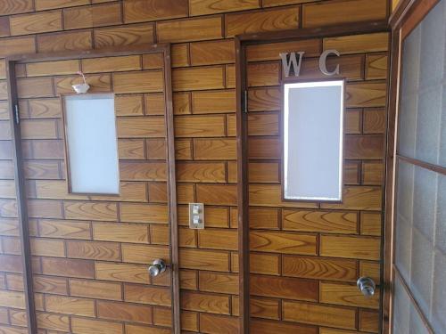 a wooden wall with two windows on it at 하루카오후나에 민숙 in Tsushima